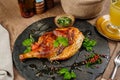 Chicken Tabaka with sauce on stone plate. Royalty Free Stock Photo