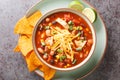 Chicken Taco Soup with black bean, corn kernels, tomatoes topped with cheddar cheese in green bowl, horizontal top view Royalty Free Stock Photo