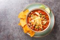 Chicken taco soup cooked in fragrant broth with beans, corn, tomatoes served with lime and tortilla chips close-up in a plate. Royalty Free Stock Photo
