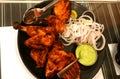 Chicken Tanduri on a plate with black background, Populer indian dish,Indian food,Delicious and spicy grilled chicken