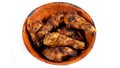 Chicken thighs marinated in spices, grilled, arranged in a fine wooden bowl, on white background Royalty Free Stock Photo