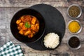 Chicken tikka masala with basmati rice in black bowl on wood Royalty Free Stock Photo