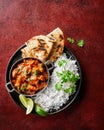 Chicken tikka masala spicy curry meat food Butter chicken, rice and naan bread on red vine dark background. Traditional Indian Royalty Free Stock Photo