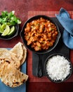 Chicken tikka masala spicy curry meat food Butter chicken, rice and naan bread on red vine dark background. Traditional Indian Royalty Free Stock Photo