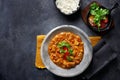 Chicken tikka masala spicy curry meat food in marbre plate with rice and spices on dark gray background