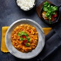 Chicken tikka masala spicy curry meat food in marbre plate with rice and spices on dark gray background