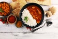 Chicken tikka masala spicy curry meat food in pot with rice and naan bread. indian food on table Royalty Free Stock Photo