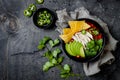Chicken tortilla chili soup with nachos, avocado, lime, jalapeno. Mexican traditional dish.