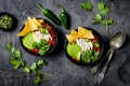 Chicken tortilla chili soup with nachos, avocado, lime, jalapeno. Mexican traditional dish.