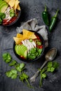 Chicken tortilla chili soup with nachos, avocado, lime, jalapeno. Mexican traditional dish.