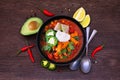 Chicken tortilla soup, overhead view with frame of ingredients on dark wood Royalty Free Stock Photo