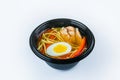 Udon Soup with egg, udon noodles and chicken fillet served in plastic delivery bowl isolated on gray background Royalty Free Stock Photo