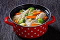 Chicken vegetable soup with pasta in red pot Royalty Free Stock Photo
