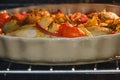 Chicken with vegetables, herbs and tomatoes is baked in the oven in a home kitchen Royalty Free Stock Photo