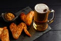 Chicken wings and beer. Hearty and tasty food. Plate of delicious barbecue chicken wings