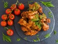 Chicken wings cooked with barbecue sauce on black stone background. Small cherry tomatoes and dill. Top view Royalty Free Stock Photo