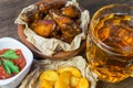 Chicken wings in a fragrant and pungent sauce with sesame seeds. A glass of fresh cold beer and fried potatoes with rustic tomato Royalty Free Stock Photo