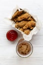 Chicken wings with ketchup, cold beer over white wooden background, top view. From above, overhead.