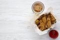 Chicken wings with sauce, cold beer over white wooden background, top view. From above.