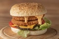 chickenburger centred on wooden plate close up