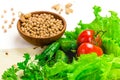 Chickpea beans in wooden bowl. fresh tomatoes, cucumbers, lettuce salad on tablecloth