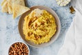 Chickpea hummus with olive oil, garlic, spices and roasted grains on kitchen table with bowl of fried chickpeas and traditional Royalty Free Stock Photo