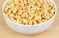 Chickpea sprouts, in a white bowl, on a wooden surface