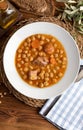 Chickpea stew dish potage - cocido madrileÃÂ±o. With beef, sausage chorizo, bacon, carrots and olive oil. Rustic appearance. Royalty Free Stock Photo