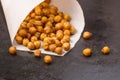 Chickpeas baked with spices closeup on black metal background with place for text