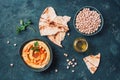 Chickpeas hummus, olive oil, raw chickpeas, smoked paprika, pita on dark background. Middle eastern, jewish cuisine or arabic