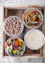 Chickpeas, pasta and corn flour in plastic jars in the wooden box