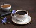 Chicory coffee and blue flowers on a dark brown background. Ground chicory root in a bowl Royalty Free Stock Photo