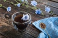 Chicory drink in thermo glass cup with fresh flowers on wooden table Royalty Free Stock Photo