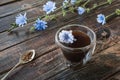 Chicory drink in thermo glass cup with instant granules in spoon on wooden table Royalty Free Stock Photo