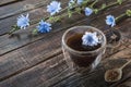 Chicory drink in thermo glass cup with instant granules in spoon on wooden table Royalty Free Stock Photo