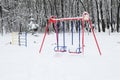 Chidren playground covered snow with colorful swing