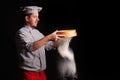 Chief cook is sifting flour through a sieve on black background Royalty Free Stock Photo