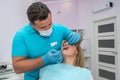 the chief dentist examines the treated healed teeth in a young woman. Royalty Free Stock Photo