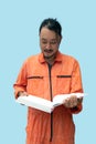 The chief mechanic in an orange uniform holding big book