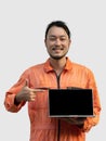 The chief mechanic in an orange uniform holding blank screen laptop