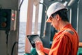 Chief officer or captain on deck of vessel or ship watching digital tablet