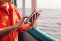 Chief officer or captain on deck of vessel or ship watching digital tablet