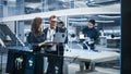 Chief Robotics Engineer Having Meeting with Project Manager and Machinery Operators Next to a Mobile