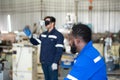 Chief and young male engineer uses a VR machine to operate a welding robot. for precision welding control