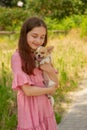 Chihuahua dog in the arms of a young girl. A teenager with a puppy