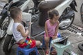 Child addiction to phones, Vietnamese children sit on the street and play on a tablet and smartphone