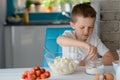 Child adding sugar to cottage cheese in a bowl.