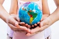 Child and Adult Holding a World Globe in Hands