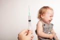 The child is afraid of a syringe, the girl yells and does not want to give an injection. Children`s fear of medical procedures. A