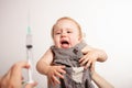 The child is afraid of a syringe, the girl yells and does not want to give an injection. Children`s fear of medical procedures. A Royalty Free Stock Photo